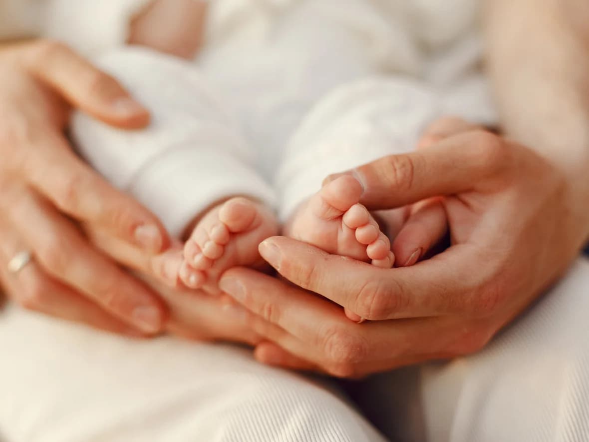 Parents holding their newborn's feet